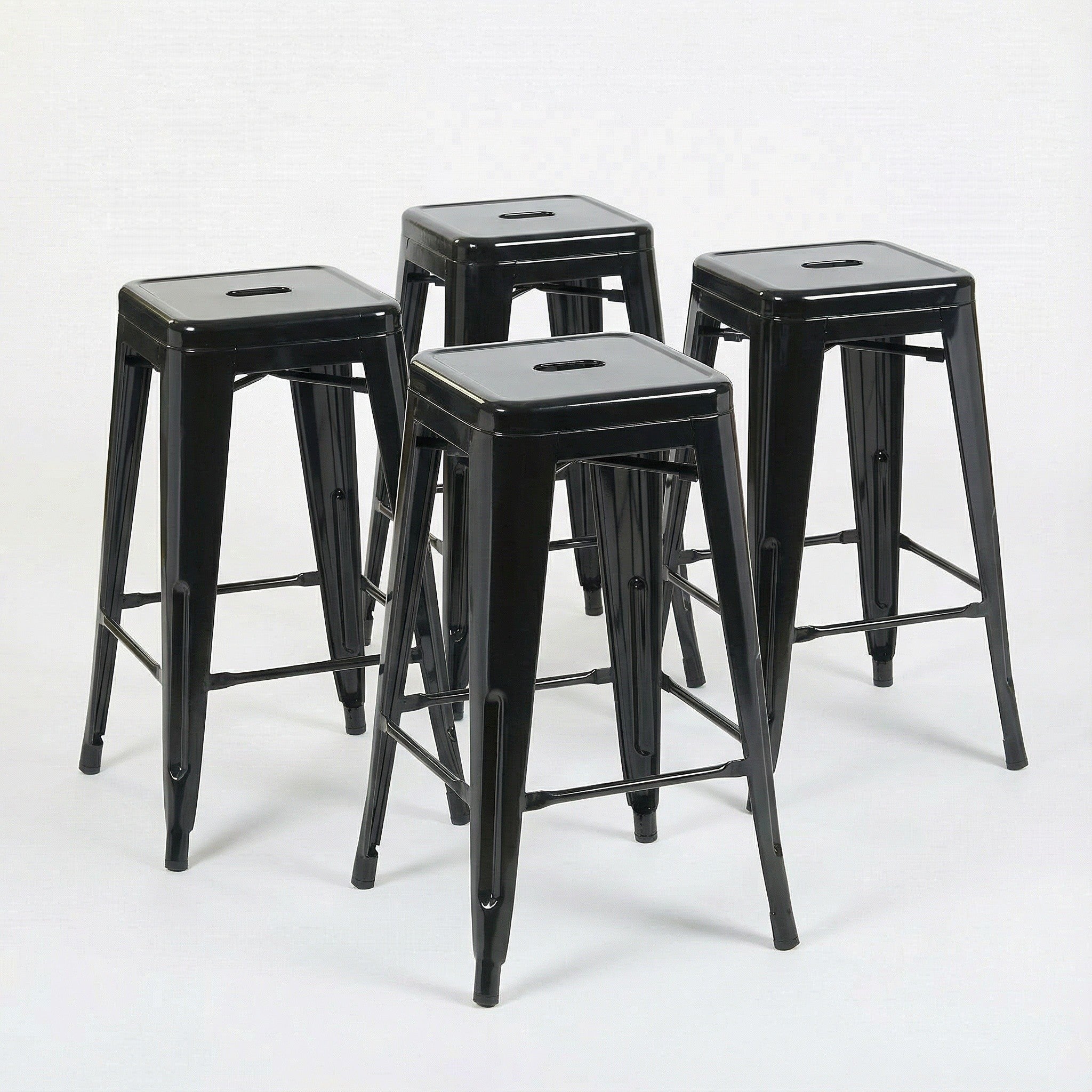 Four black metal bar stools on a white background