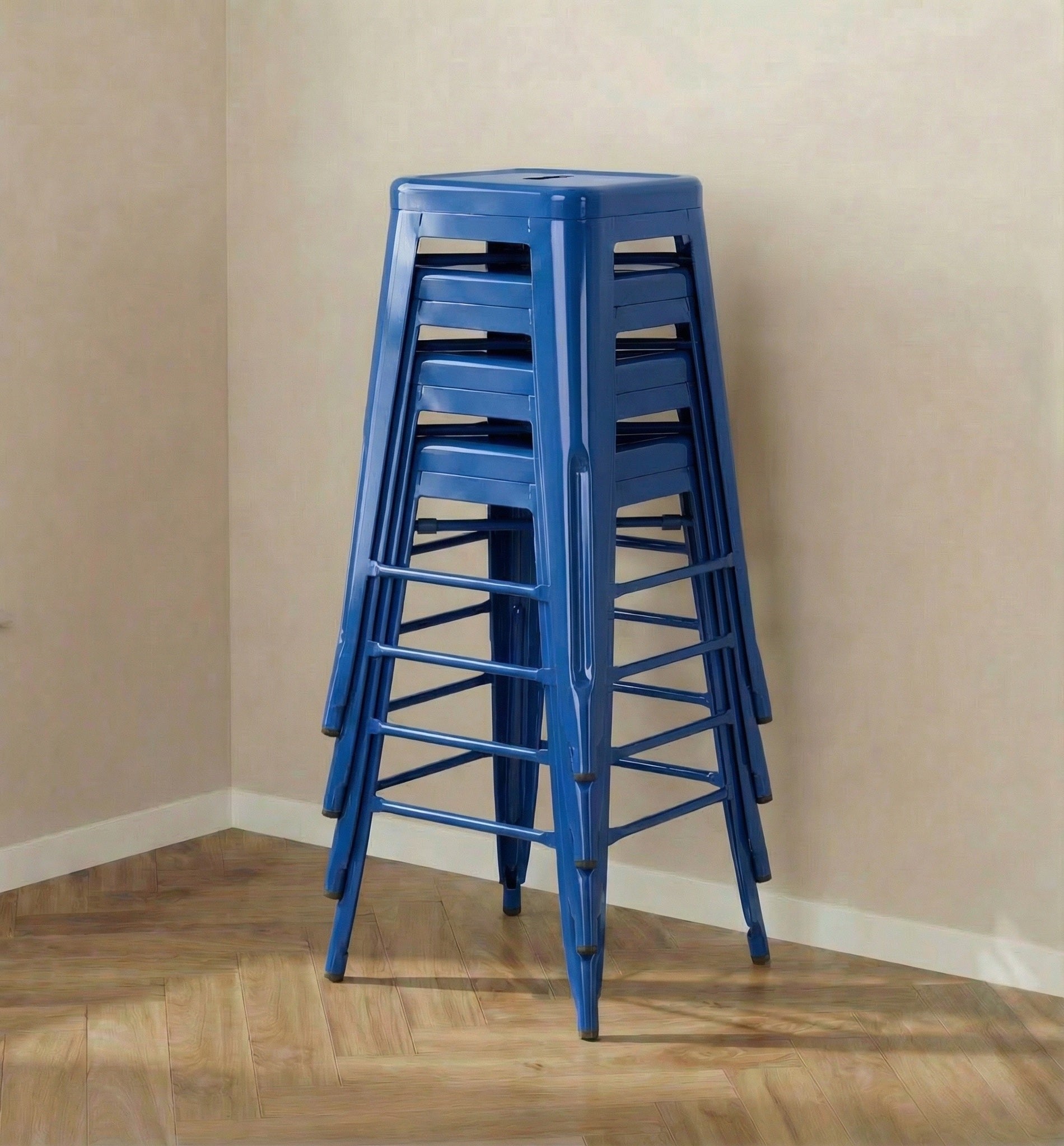 Stack of blue stools against a beige wall.