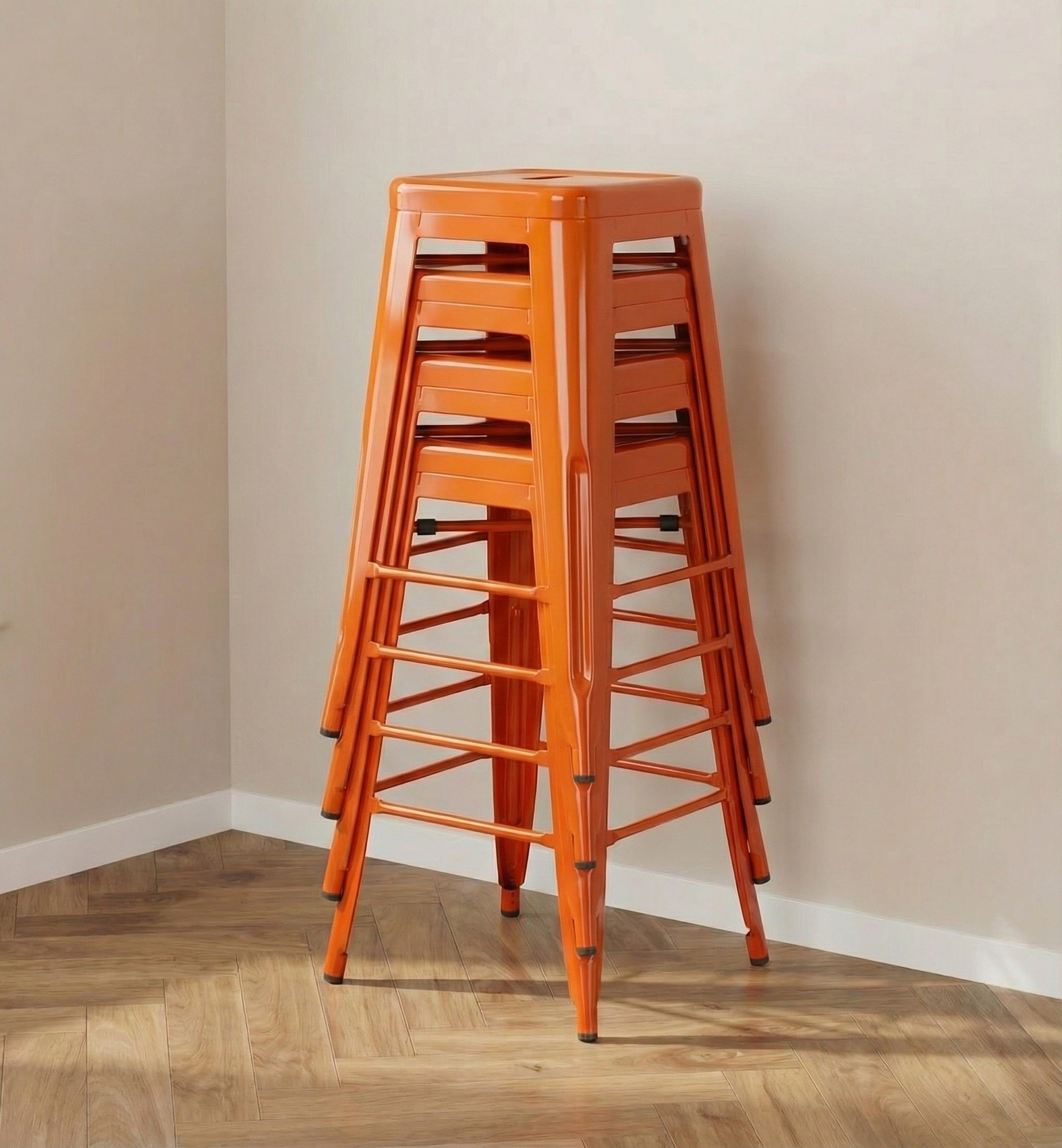 Stack of orange stools against a beige wall.
