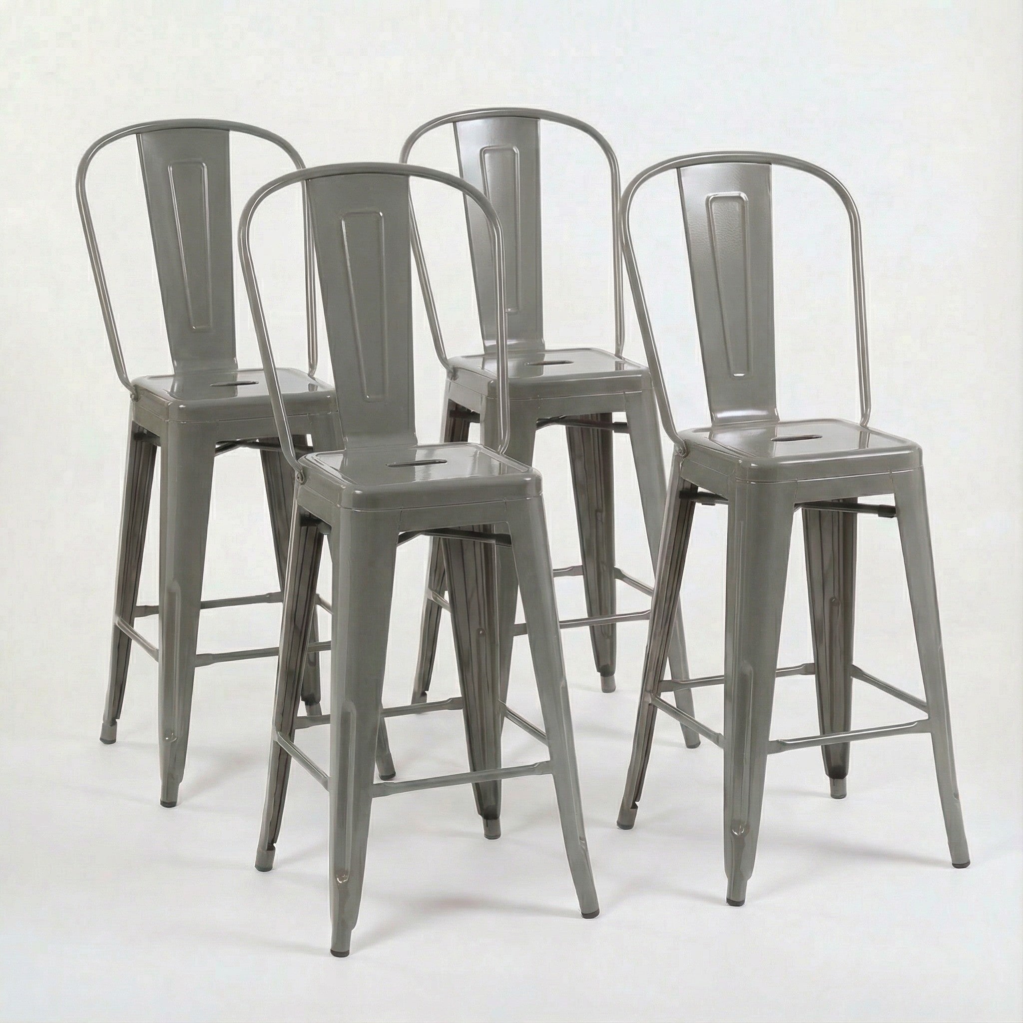 Set of four gray metal bar stools on a white background