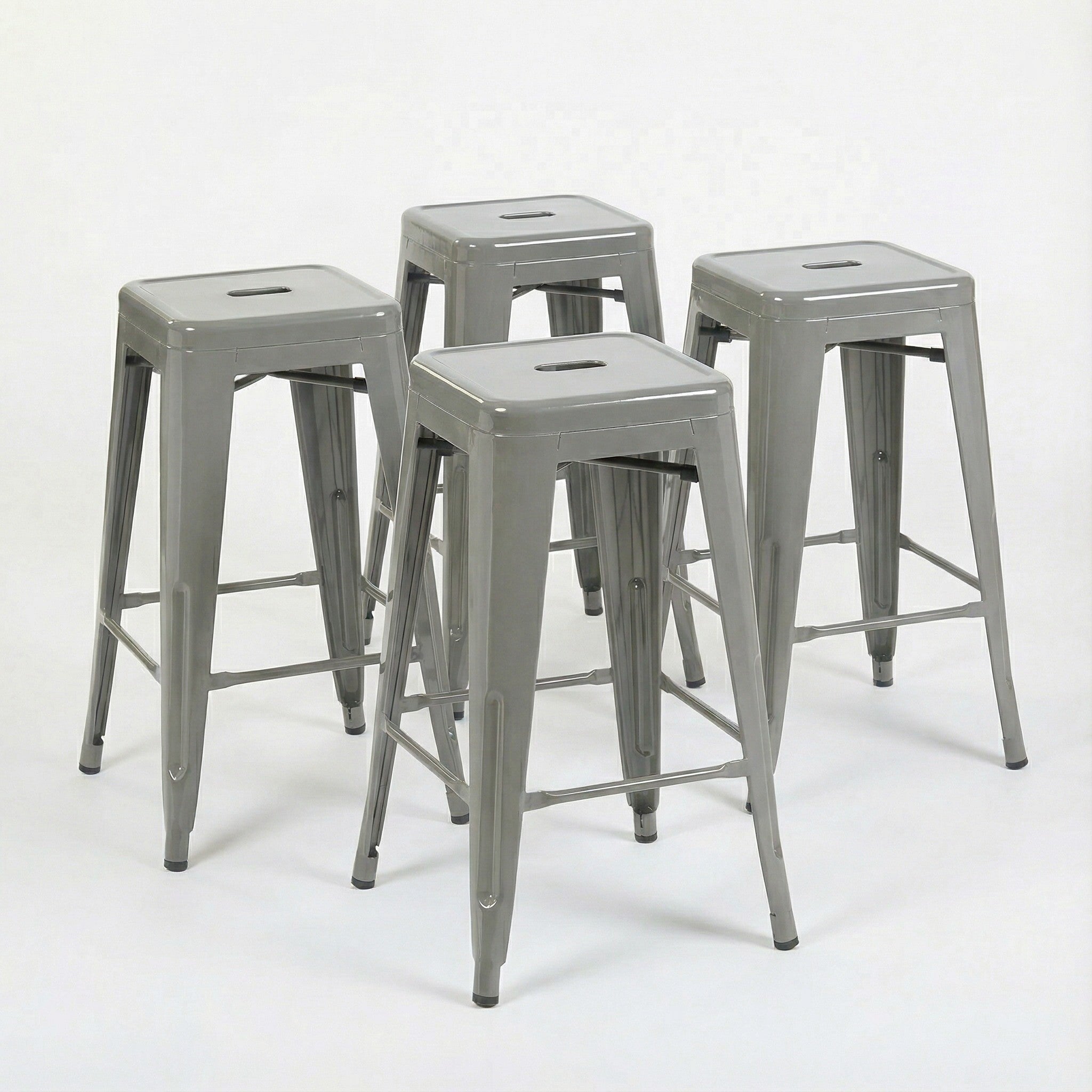 Four gray metal bar stools on a white background