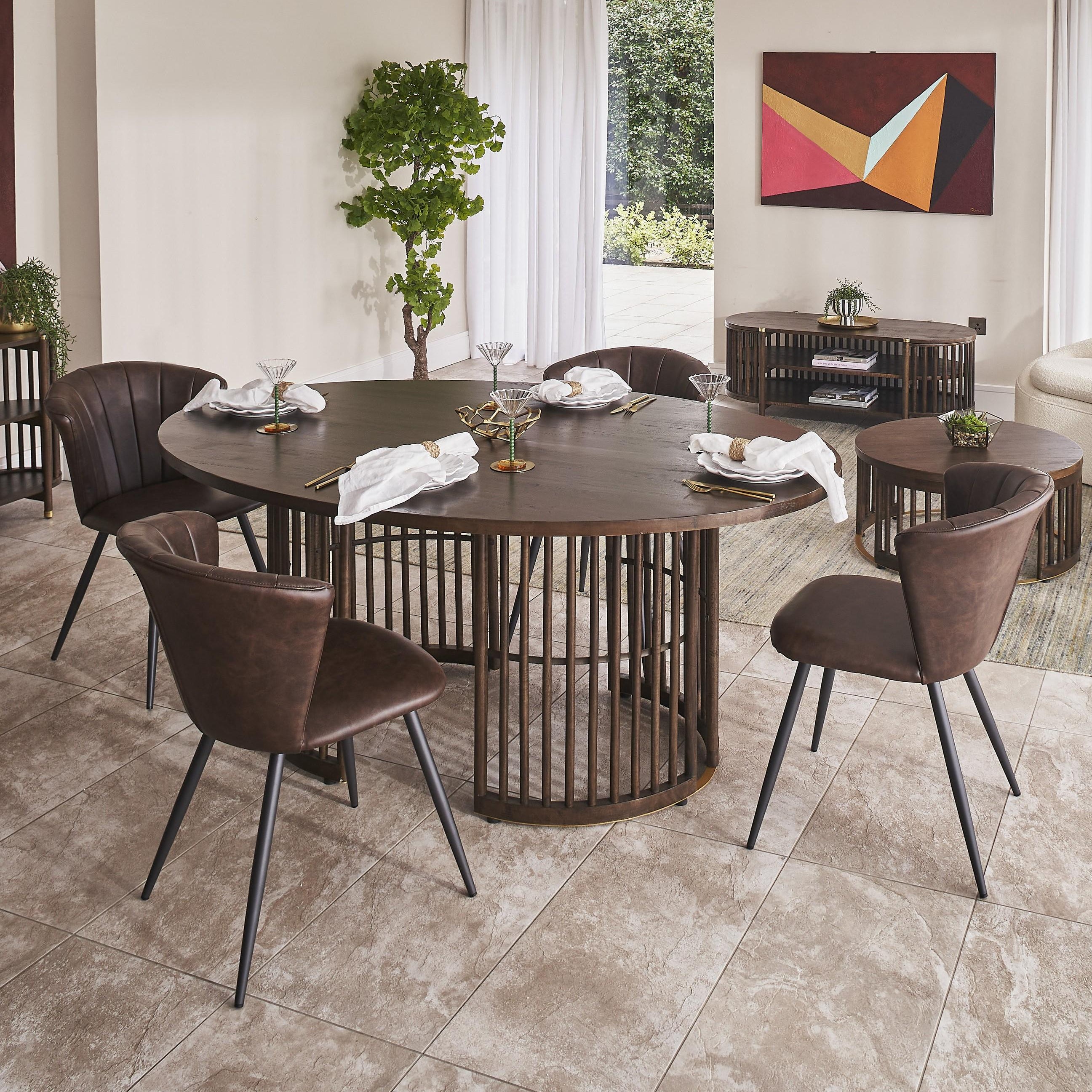 Modern dining room with round wooden table and chairs, large windows, and decorative plants.