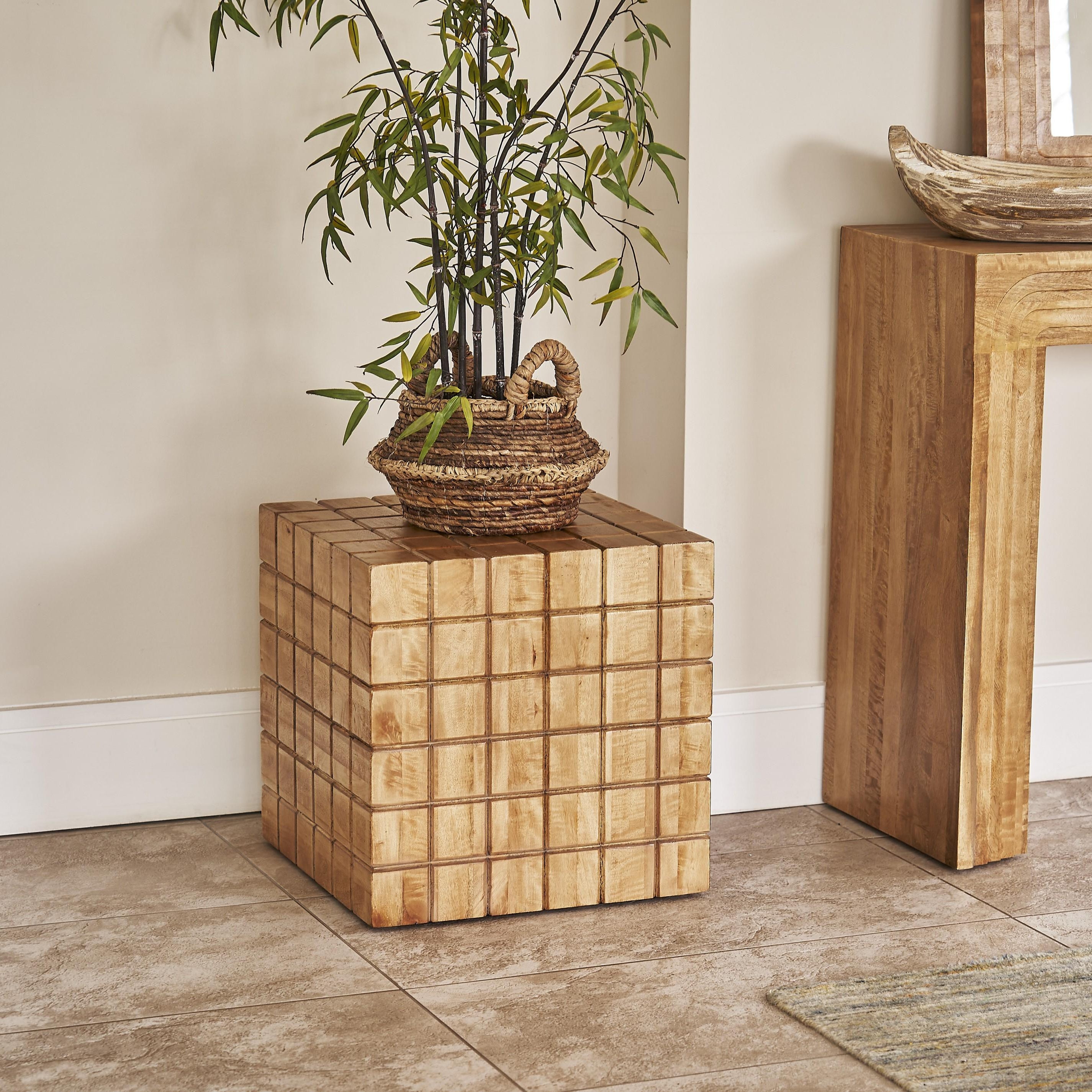 Wooden side table with a plant and mirror on a light-colored floor.