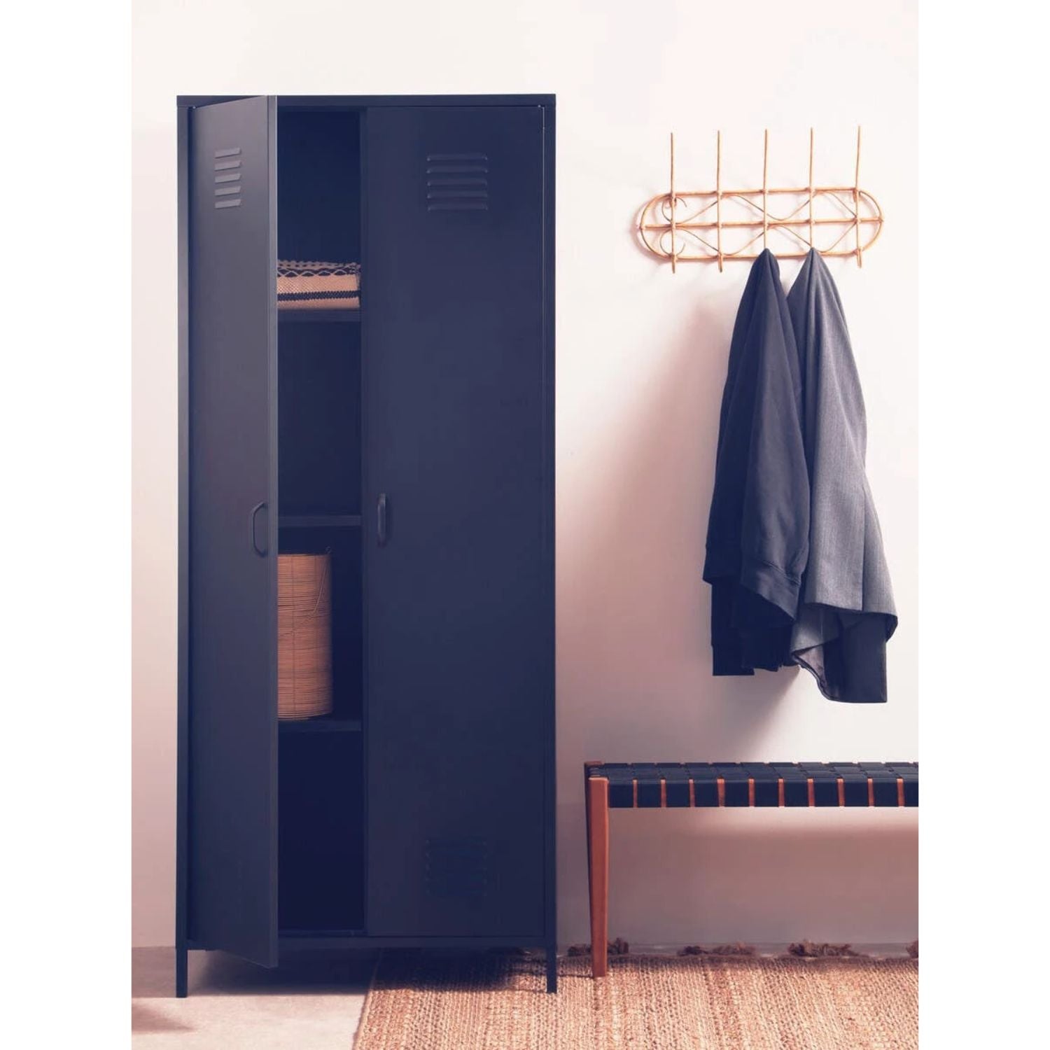 Blue locker with clothes hanging on a hook next to it in a room.