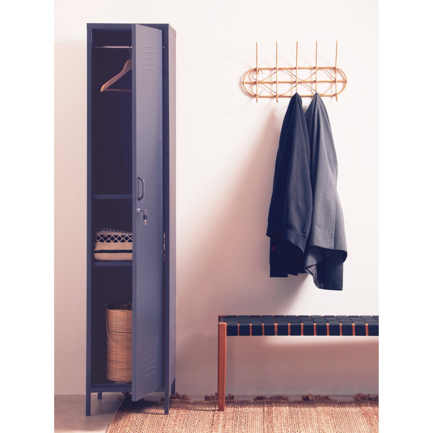Blue locker with open door, clothes hanging on a rack, and a bench in a room.