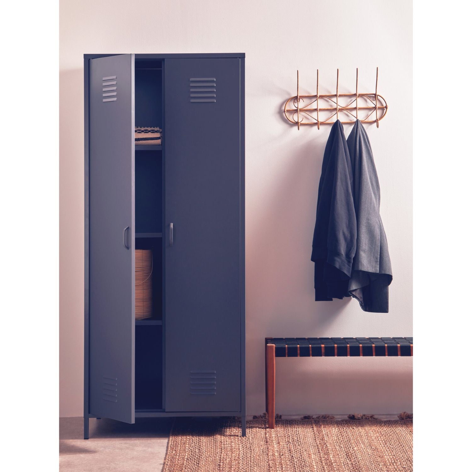 Blue locker with open door, clothes hanging on a rack, and a bench in a room.