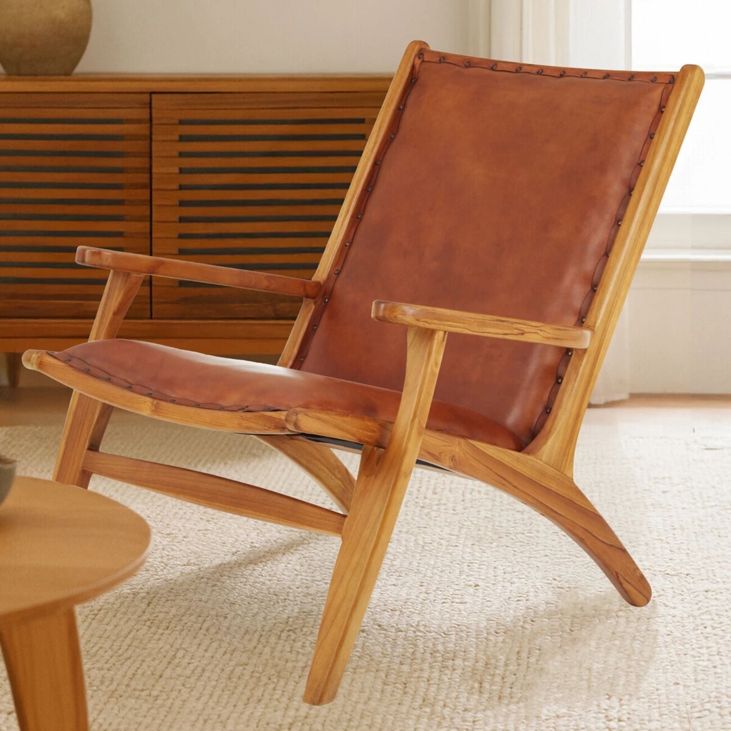 Brown leather chair with wooden frame in a room setting